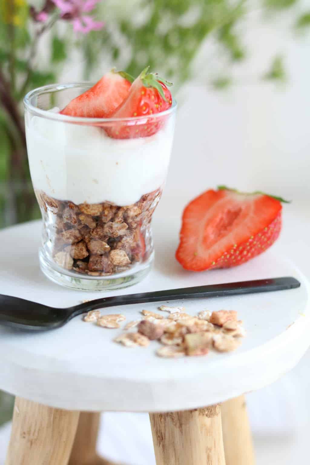 Pindakaas muesli met kwark. Door de pindakaas, muesli, honing en cacao te mengen ontstaat een koekbodem met kwark en fruit on top. Wie lust dit nu niet?