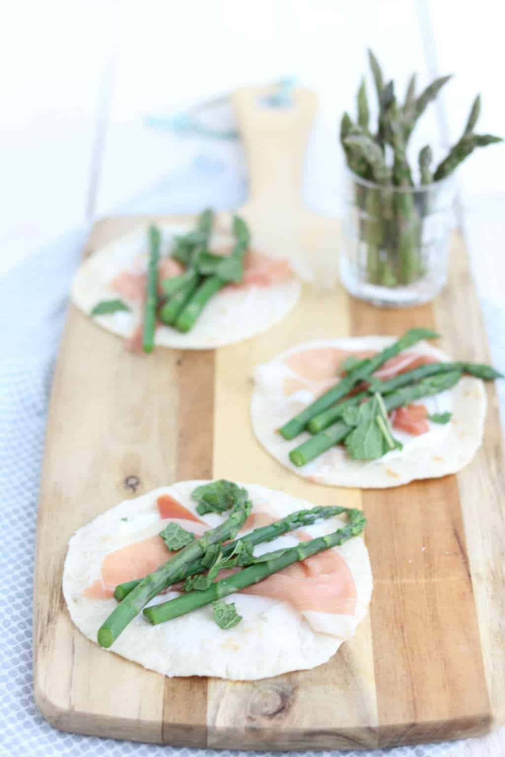 Wraps met asperges en geitenkaas, rauwe ham en munt. Een heerlijk hapje voor bij de borrel of gewoon als avondmaaltijd met een groene salade erbij.