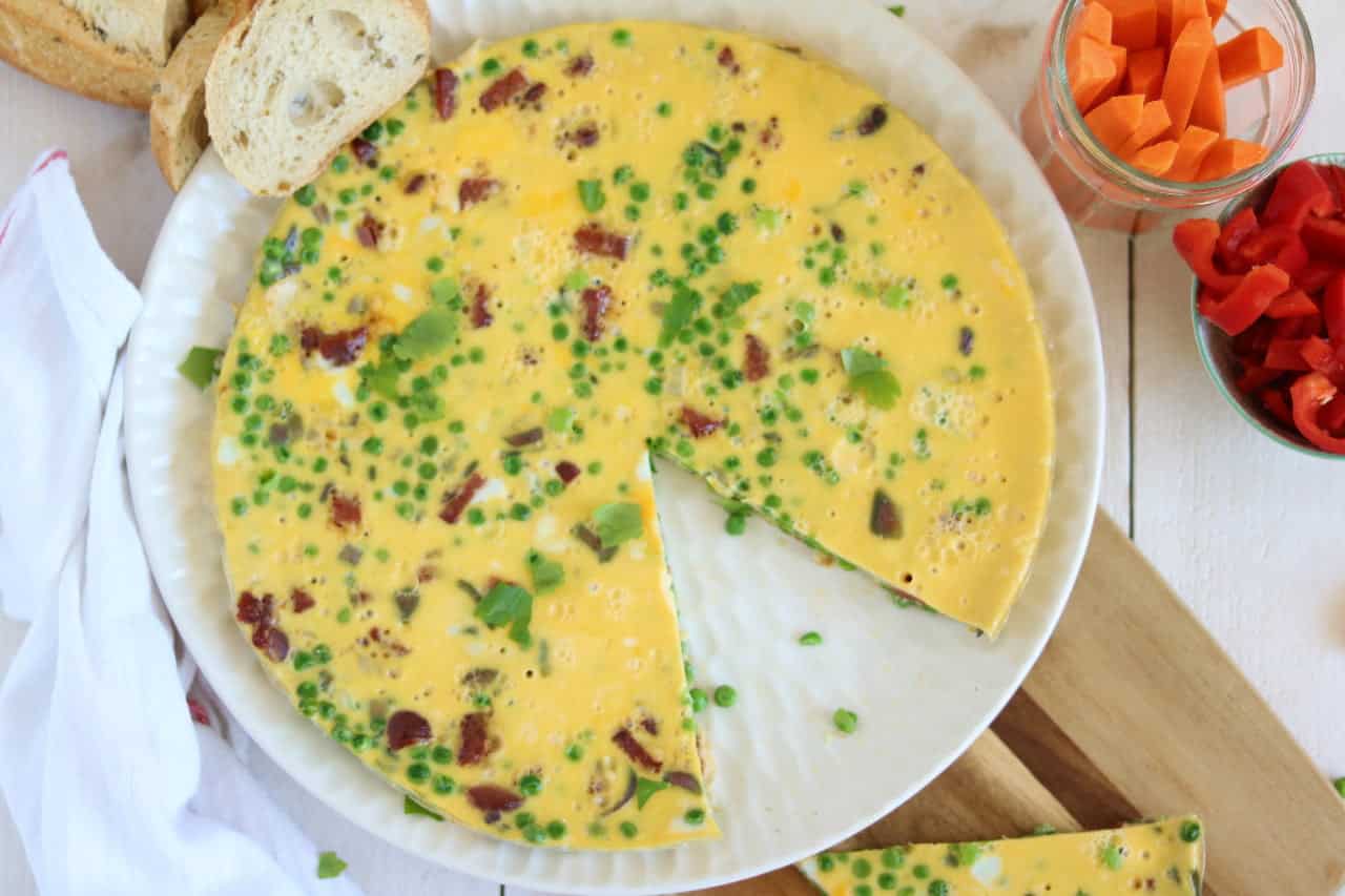 Frittata met salami, ui en doperwten. Een makkelijke maaltijd voor op vakantie of de camping. Serveer met stokbrood en een salade.