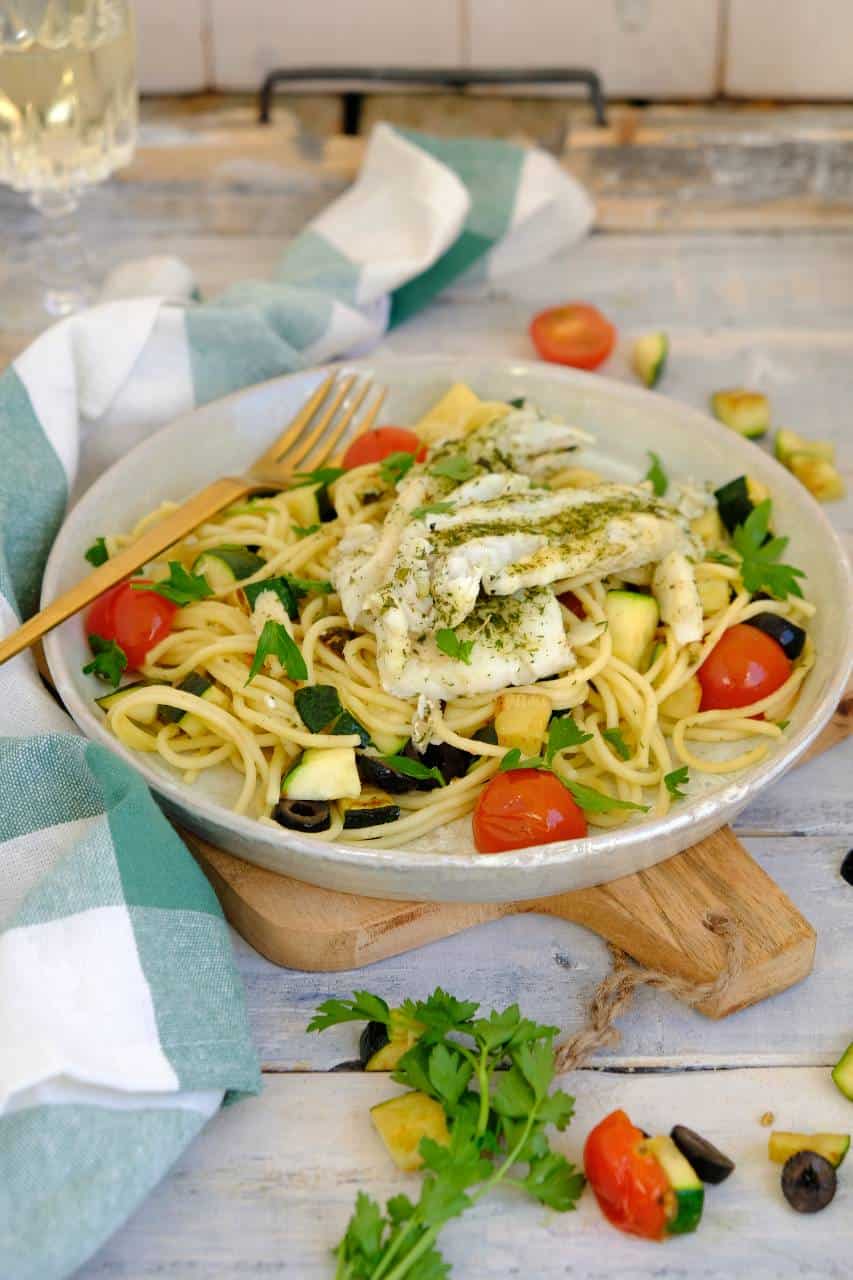 Spaghetti met kabeljauw is een makkelijk vis recept voor doordeweeks. Lekker met courgette, cherry tomaatjes en olijven.