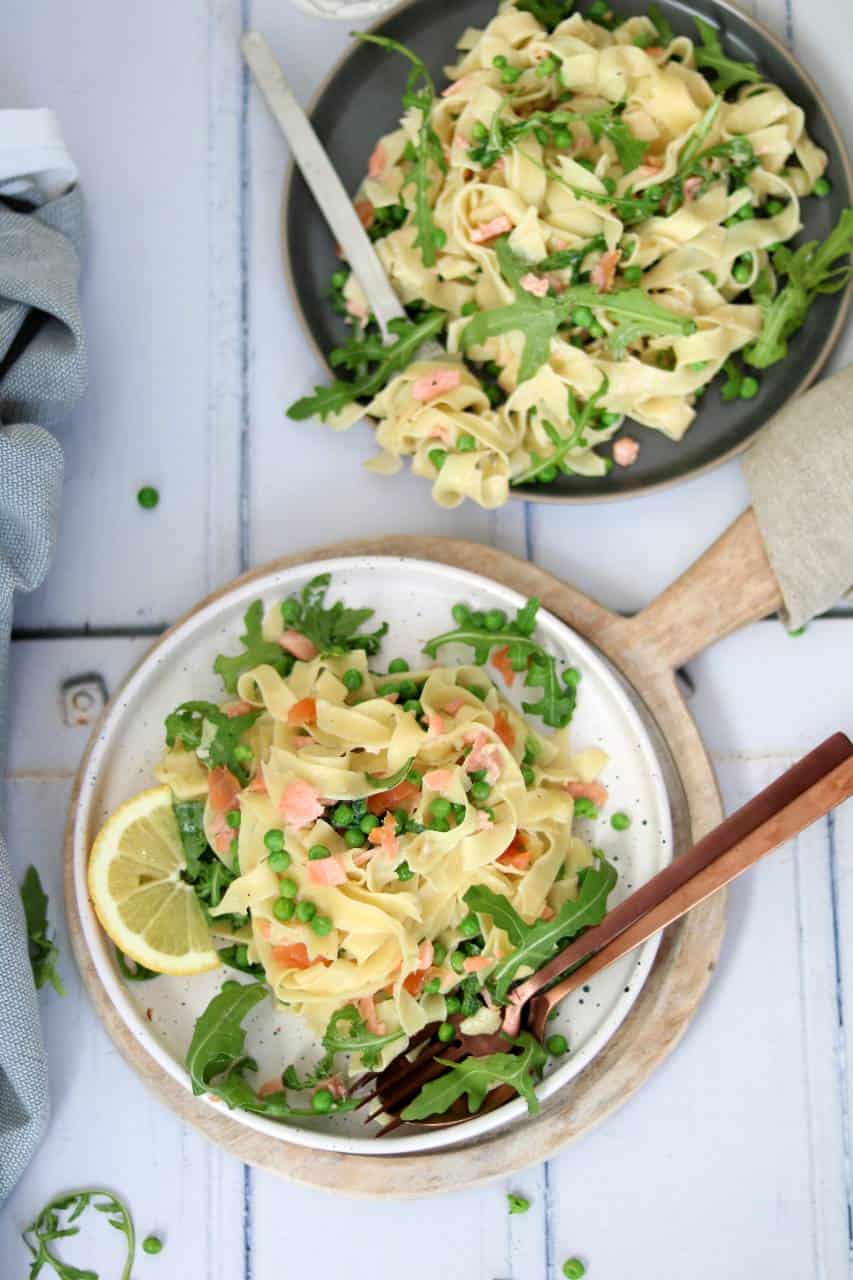 Pasta met zalm en roomsaus. De pastasaus is lekker romig en fris door de doperwten, citroen en rucola. Geniet ervan!