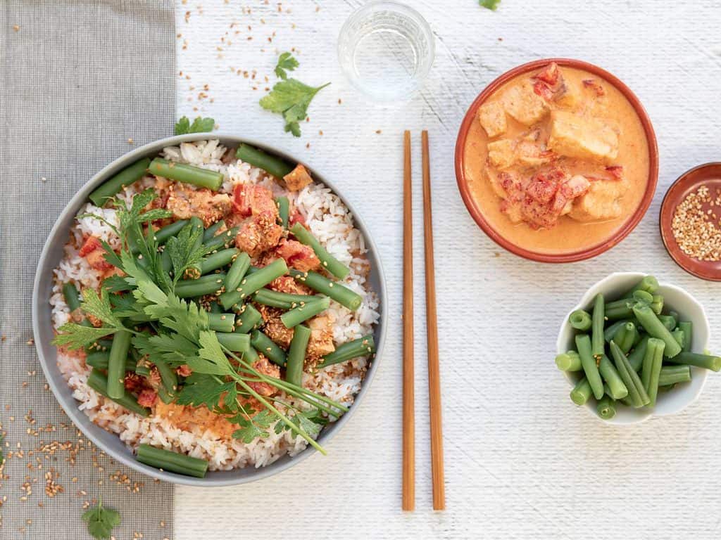 Thaise curry met vis. Dit rode curry recept zit bomvol smaak, zonder te pittig te zijn. De vis (kabeljauw) gaart in de rode curry met kokosmelk en tomaat. Combineer de Thaise curry met rijst en groente naar keuze.