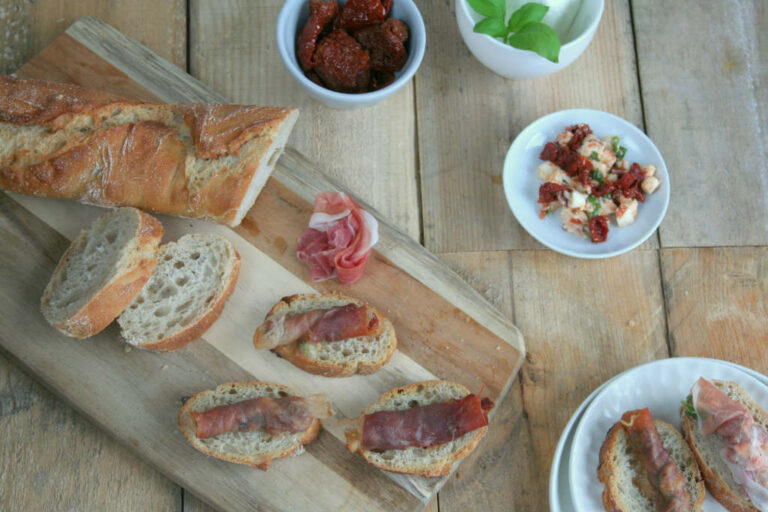 Crostini met rauwe ham, zongedroogde tomaat en mozzarella
