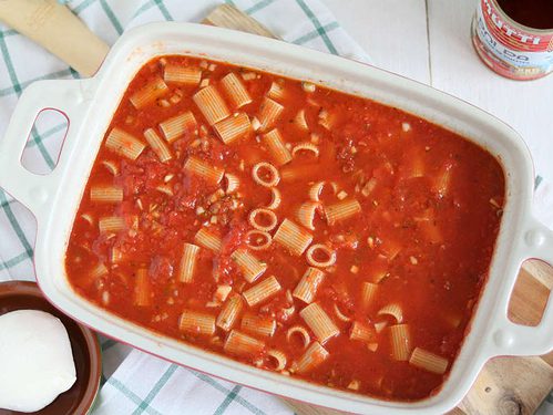 Vegetarische pasta ovenschotel, alle ingrediënten ongekookt in de ovenschaal.