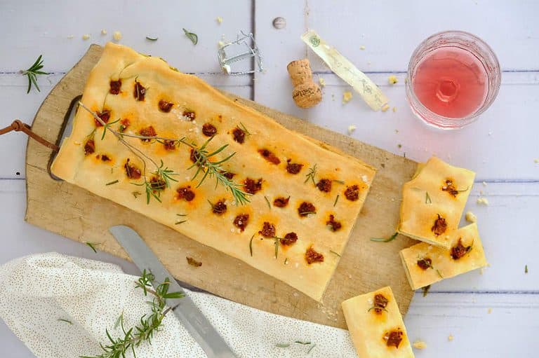 Een snelle focaccia met pesto en zongedroogde tomaat maak je makkelijk met een verse rol pizzadeeg. Dit hapejs recept serveer je warm of koud.