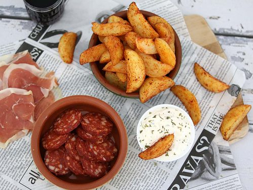 Patatas bravas met knoflooksaus maak je thuis eenvoudig zelf met voorgekookte aardappelpartjes. Voor erbij serveer je een frisse knoflooksaus.
