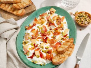 Burrata plank, de borrelhap die je in een handomdraai maakt met proscuitto, nectarine en pistache